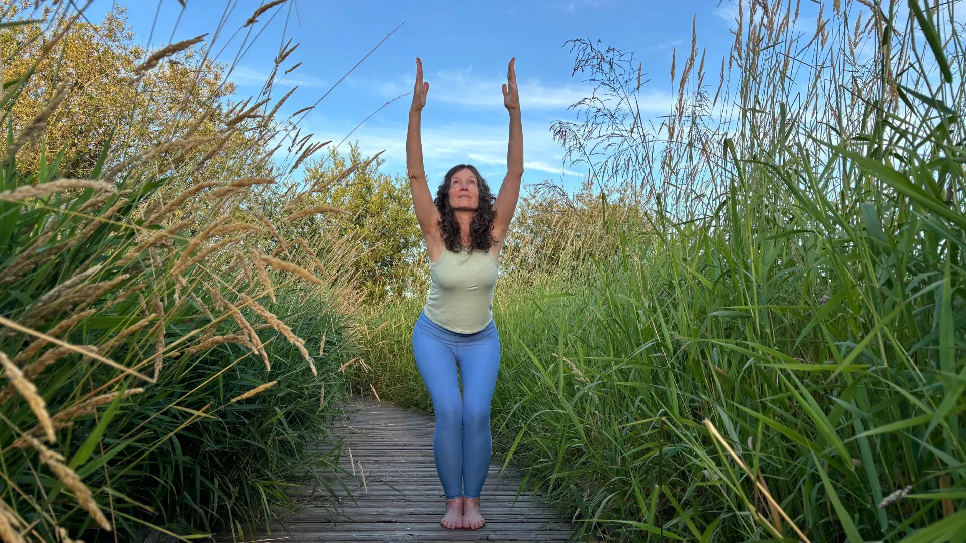Melissa Lutz Blouin practicing yoga outdoors on a boardwalk